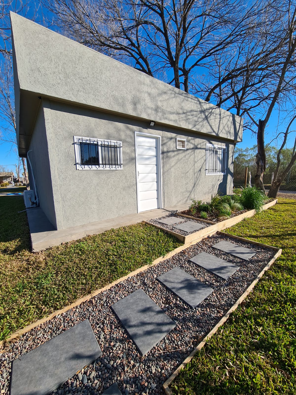 Casa Laurel – exterior con árbol y jardín