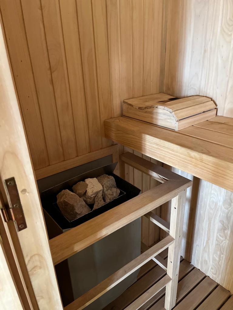 Sauna de madera con piedras volcánicas